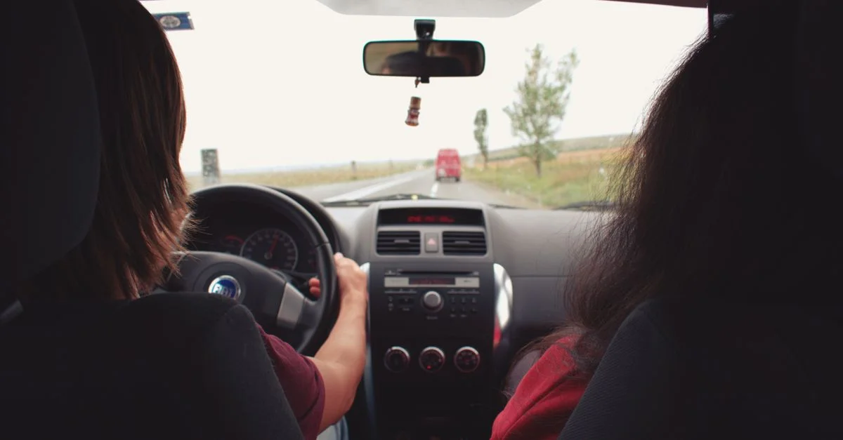 Deux adultes en voyage en voiture sur une route pittoresque près de Iași, Roumanie.